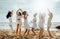 Group of girlfriends dancing at the beach, female friends having fun, enjoying bachelorette celebration on ocean shore