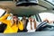 Group of girls having fun in the car, singing songs and dancing in car during road trip