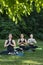Group of girls meditate in the morning in park. Morning yoga practice outside. Young women in park do yoga