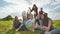 A group of girls students sit in the meadow and toss the world globe up.