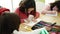 Group of girls students sitting on table drawing on notebook at classroom