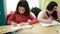 Group of girls students sitting on table drawing on notebook at classroom