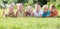 Group of glad kids lying on green grass in park