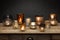 A group of glass tea light holders and glowing candles, shot on a wooden table
