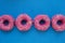 Group of glazed pink donuts on a blue background