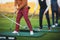 Group of golfers practicing and training golf swing on driving range practice, men playing on golf course, golf ball at golfing