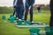 Group of golfers practicing and training golf swing on driving range practice, men playing on golf course, golf ball at golfing