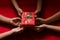 Group of Hand Kids Hold Christmas Gift Box on Red Background.