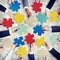 Group of Hands Holding Colourful Jigsaw Pieces