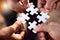 Group hands with puzzle for solution, teamwork and workflow goals, achievement and success in closeup. Team building