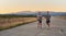 Group of handsome men running together in the early morning glow of the sunrise, embodying the essence of fitness