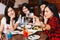 Group of Happy Asian male and female friends taking a selfie photo and having a social toast together in restaurant