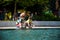 Group of happy children playing outdoors near pool or fountain. Kids having fun in park during summer vacation. Dressed in