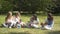 Group of happy children playing outdoors in the summer Park. Mothers look after their children sitting on the grass.