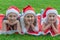 Group of happy children in santa claus hat lies in the park on the green grass and smiling. The concept of a new year, christmas