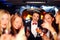 Group of happy elegant women clinking glasses in limousine, hen party