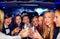 Group of happy elegant women clinking glasses in limousine, hen party