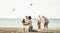 Group of happy families with parent and children playing with kite at beach vacation - Summer joy carefree concept with mixed