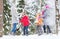 Group of happy friends playing snowballs in forest