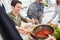 Group of happy friends serve pasta with tomato sauce