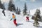 Group of happy friends snowboarders and skiers riding on ski slope and having fun