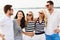 Group of happy friends in striped clothes on beach