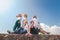 Group of happy joyful young stylish girls travel together, in hats against a blue sky