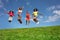 Group of happy kids jump high over sky on lawn