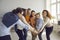 Group of happy motivated diverse business people joining hands in office meeting