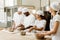 group of happy multiethnic bakers kneading