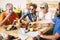 Group of happy people having breakfast at home in the terrace together with love - faughter, son, grandma and grandpa eating and