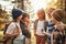 Group of happy school kids in casual clothes with backpacks exploring nature and forest together