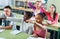 Group of happy school pupils raise their hands up