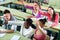 Group of happy school pupils raise their hands up