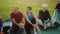 Group of happy senior friends taking a break sitting on mat after workout activity