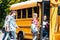 group of happy teen scholars entering school bus