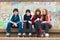 Group of happy teenagers in roller skates sitting