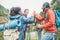 Group of happy trekkers stacking hands outdoor - Young hiker friends supporting each others - Survival, team, travel, success and