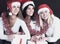 Group of happy women in costumes of Santa Claus and Christmas sh