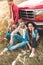 group of happy young car travellers sitting on flower field and leaning back