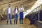 Group of happy young cattle farm workers standing in a livestock barn and smiling