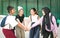 Group of happy young college students putting and stacking their hands together