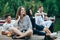 Group of happy young friends relaxing on river pier