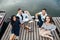 Group of happy young friends relaxing on river wooden pier