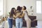 Group of happy young women hugging their friend and congratulating her on success