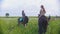 Group of happy young women riders on horseback stands among the meadow