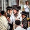 A group of Hasidim pilgrims in traditional clothing emotionally talk. Rosh hashanah holiday, Jewish New Year.