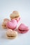 A group of heart-shaped French macaron cookies, vanilla and strawberry flavour, copy space on neutral background