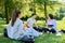 Group of high school students with female teacher, on campus lawn