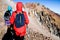 Group of hikers ascending stony mountain